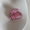 Detail of pink checkered shark hair clip with gold logo on a white textured ceramic tray - Pink Plaid Series - Small Fan Claw