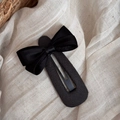 Détail d'une barrette à cheveux avec noeud noir en satin sur un tissu de fond beige doux - Pince BB Goutte avec Nœud Noir / Noir et Gris