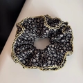 Détail macro d'un chouchou floral surdimensionné avec bordure en dentelle jaune et tissu noir - Style Taille Cintré Bord Ondulé / Petit Imprimé Floral Noir