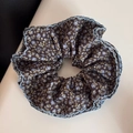 Détail d'un chouchou floral marron foncé avec bordure festonnée en crochet bleu clair - Style Taille Cintré Bord Ondulé / Floral Café