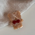 Dettaglio del fermaglio per capelli a forma di orso marrone con fiocco rosso - Albicocca