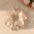 Detailed close-up of a floral scrunchie with pink bows and a handmade textile label - Sweet Pink Bow Floral