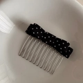 Nahaufnahme von schwarz-weißem gepunktetem Haarkamm mit silbernen Metallzinken in Schale - Schwarz Punktmuster Schleife Haarkamm
