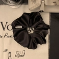 Dettaglio dell'elastico in raso nero di lusso con lucentezza della seta e etichetta bianca - Nero