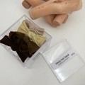 Vista dettagliata di 5 elastici per capelli color terra con scatola trasparente - Fiocco Marrone Caffè