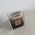 Détail d'élastiques à cheveux dégradés tons terre dans une boîte cadeau transparente - Couleurs café