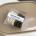 Détail de 6 élastiques spirales crème et marron café dans une boîte transparente - Crème 3 + Kaki 3