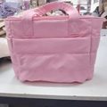Detail of pink quilted puffer tote showing padded handles and side storage pockets - Pink