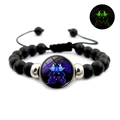 Detailed view of Gemini constellation glowing glass bead on black beaded bracelet - Gemini