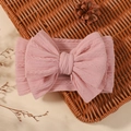 Soft light pink knitted baby headband featuring a large bow and cable knit texture - Light Pink