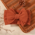 Elastic baby bow headband in rust red knitted jacquard fabric for infants - Caramel color