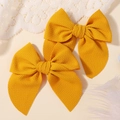 Détail de barrettes à nœuds jaune moutarde texture gaufre pour enfants sur dentelle - Gingembre (2A-17)