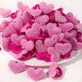 Gros plan d'élastiques à cheveux roses en forme de cœur à paillettes sur une assiette décorée - Cœur / Rose