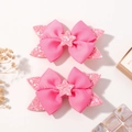 Set of two cute pink bow hair clips for girls featuring sparkling glitter stars and dots - Light Pink