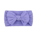 Close-up of a soft purple knitted baby headband featuring a large bow and cable pattern - Purple (25)