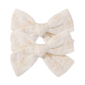 Detail of two cream floral embroidered cotton bow hair clips showing textured fabric craft - Off-White Floral Embroidery