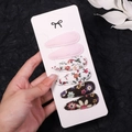 Close-up of floral fabric hair clip set with wave-stitch edges on a card display - Pink Floral Brown (2757-11)