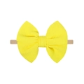 Detail van gele wafelstof strik op een zachte nylon haarband voor baby's - Heldergeel