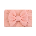 Détail du bandeau bébé rose pêche avec un grand nœud en maille gaufrée sur tissu lisse - Rose Pêche (720)