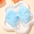 Dettaglio del fermaglio per capelli in mesh celeste con fiocco a doppio strato e pois flock - Azzurro