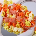 Gros plan d'élastiques à cheveux en tissu étoilé jaune et orange sur un socle blanc - Lot de 30 / Jaune Orange Blanc (30E)