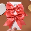 Paire de barrettes à nœuds en satin rouge corail pour filles sur carte blanche - 2 Pièces/Ensemble / Corail