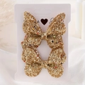 Coppia di fermagli per capelli a farfalla dorati con glitter per bambine su carta bianca - Duo Paillettes Oro (2A-56)