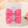 Set of two handmade bows in vibrant hot pink and lilac purple on a display card - Peach Pink and Purple (2A-5)