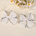 Pair of large white fabric bow hair clips with black wavy edges and satin finish center - White with Black Trim
