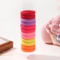 Colorful elastic nylon hair ties in various vibrant shades of red and pink on a stand - Warm Color Palette (12N)