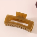 Detail view of the amber translucent rectangular hollow hair claw with metal spring - Bulk Packaging / Olive Green