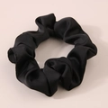 Close-up of black satin hair scrunchie with soft pleated texture and silk-like shine - Black