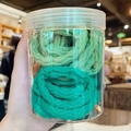 Detail of green gradient thick hair ties with ribbed texture in a clear storage jar - Green