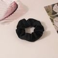 Elegante coletero de satén negro con textura plisada sobre un escritorio de estética minimalista - Negro