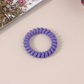 Detail of a dark purple matte spiral telephone cord hair tie on a minimalist background - Matte Deep Purple