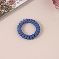 Close-up of a matte dark blue spiral phone cord hair tie on a minimalist pink background - Matte Navy Blue