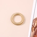 Close-up of a high-elastic gold spiral hair tie with a glossy metallic finish - Metallic Gold
