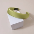 Close-up of green satin wide headband featuring a black Hand Made woven label inside - Satin Grass Green