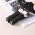 Clip volumizzanti per radici in velcro nero con impugnature beige su una rivista di moda - Nero