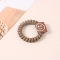 Élastique cheveux spirale marron avec étiquette en tissu arborant un visage souriant - Étiquette Smiley Café