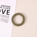 Elastic olive green spiral telephone wire hair tie on a minimalist beige background - Glossy Olive Green