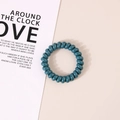 Elastic dark cyan spiral hair tie in a minimalist design on a plain beige background - Glossy Peacock Blue
