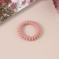 Pink spiral telephone wire hair tie with orange speckles on a cozy beige background - Matte Dark Pink