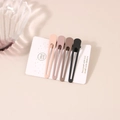 Detail of four matte duckbill hair clips in cream and coffee tones on a soft pink surface - 4-Piece Hollow Teardrop Duckbill Clip (D4184)