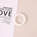 Minimalist white spiral telephone wire hair tie on a pink background for women - Glossy White