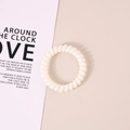 Coletero blanco minimalista en forma de espiral sobre fondo beige decorativo - Blanco Crema Brillante