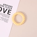 Elastic pale yellow spiral telephone wire hair tie on a minimalist beige background - Glossy Yellow