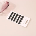 Detail of 30 black metal bobby pins with wavy design on a classic white display card - Black Series