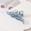 Détail d'une pince à cheveux vague bleu-gris translucide sur un plateau blanc - Bleu-Transparent
