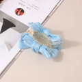 Détail de la pince à cheveux avec nœud en satin bleu clair et texture tissu élégante - Bleu